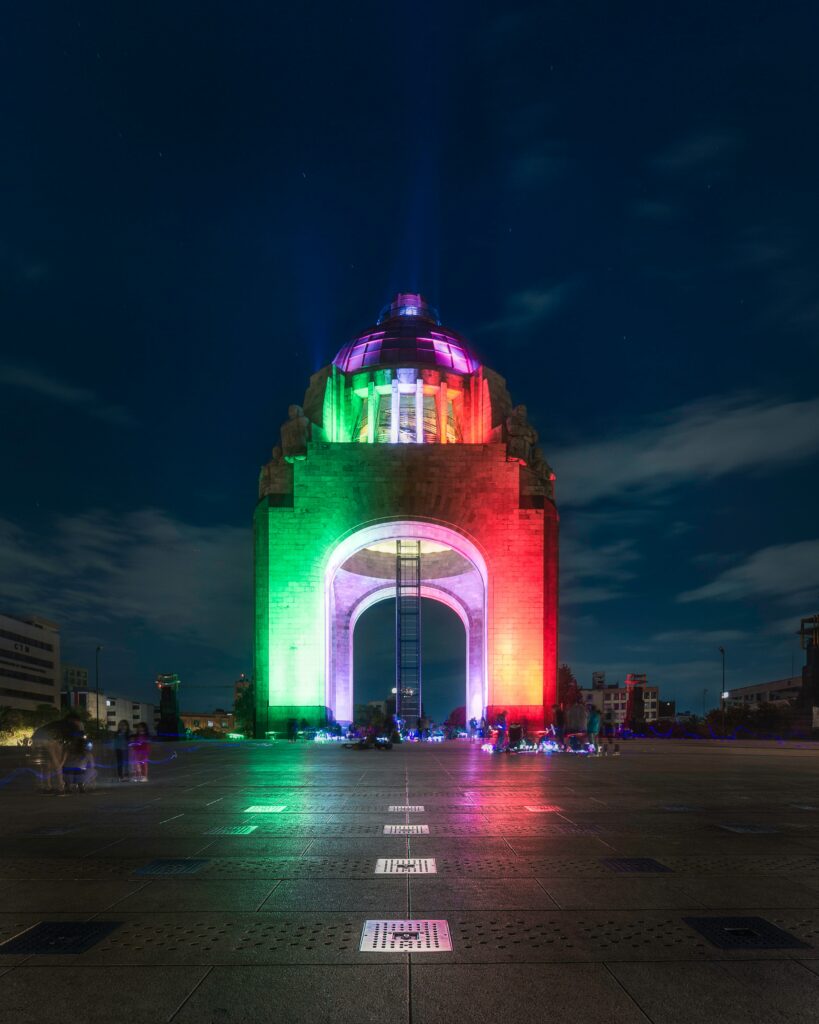 Monumento mejicano iluminado con colores bandera